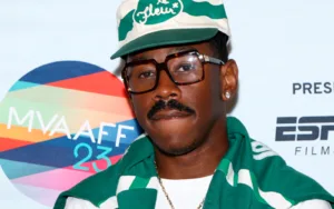 Retrato de Tyler, the Creator, nombrado Artista del Año 2025 por Apple Music, luciendo gafas y una gorra "le Fleur".