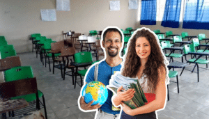 Un maestro con un globo terráqueo y una maestra con libros sonriendo frente a un salón de clases vacío para celebrar el Día del Maestro 2026 en México.
