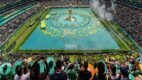 Vista de un estadio de la Copa del Mundo 2026 completamente lleno con miles de aficionados, banderas y una pantalla gigante que ilustra el impacto global y los récords de audiencia de las transmisiones.