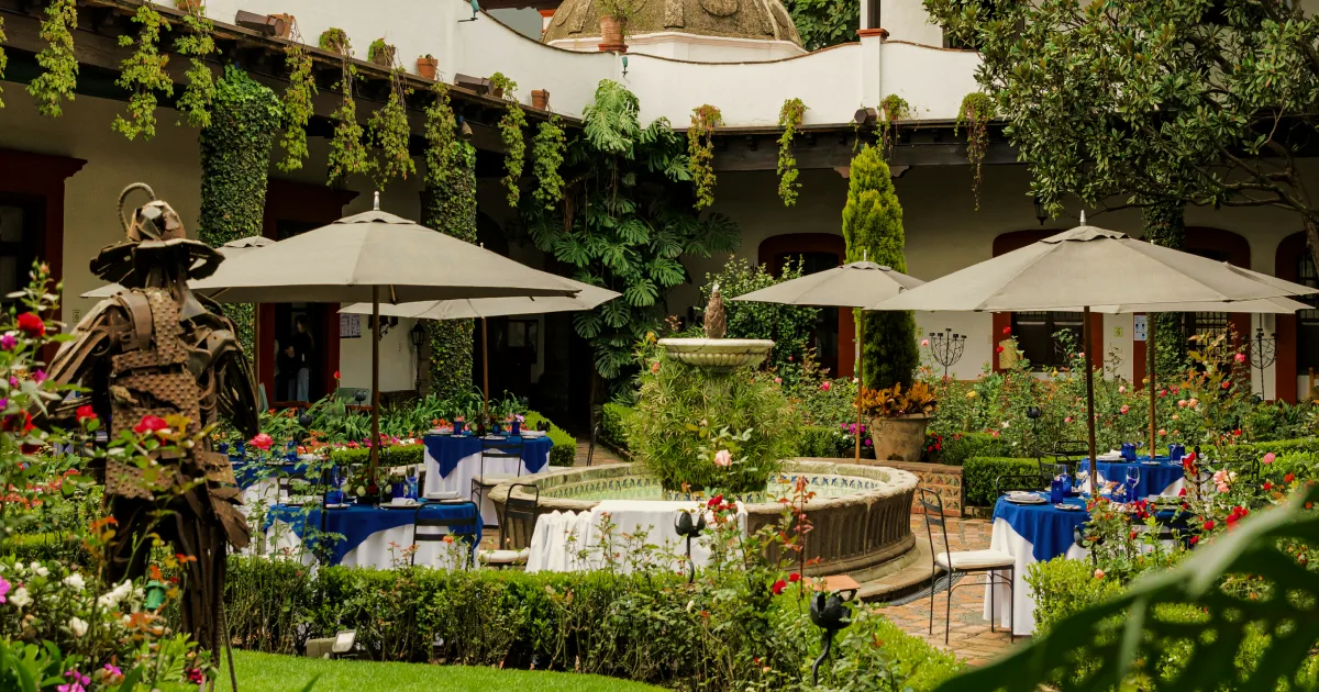 Restaurante mexicano fino en un antiguo monasterio con mesas al aire libre alrededor de una fuente.