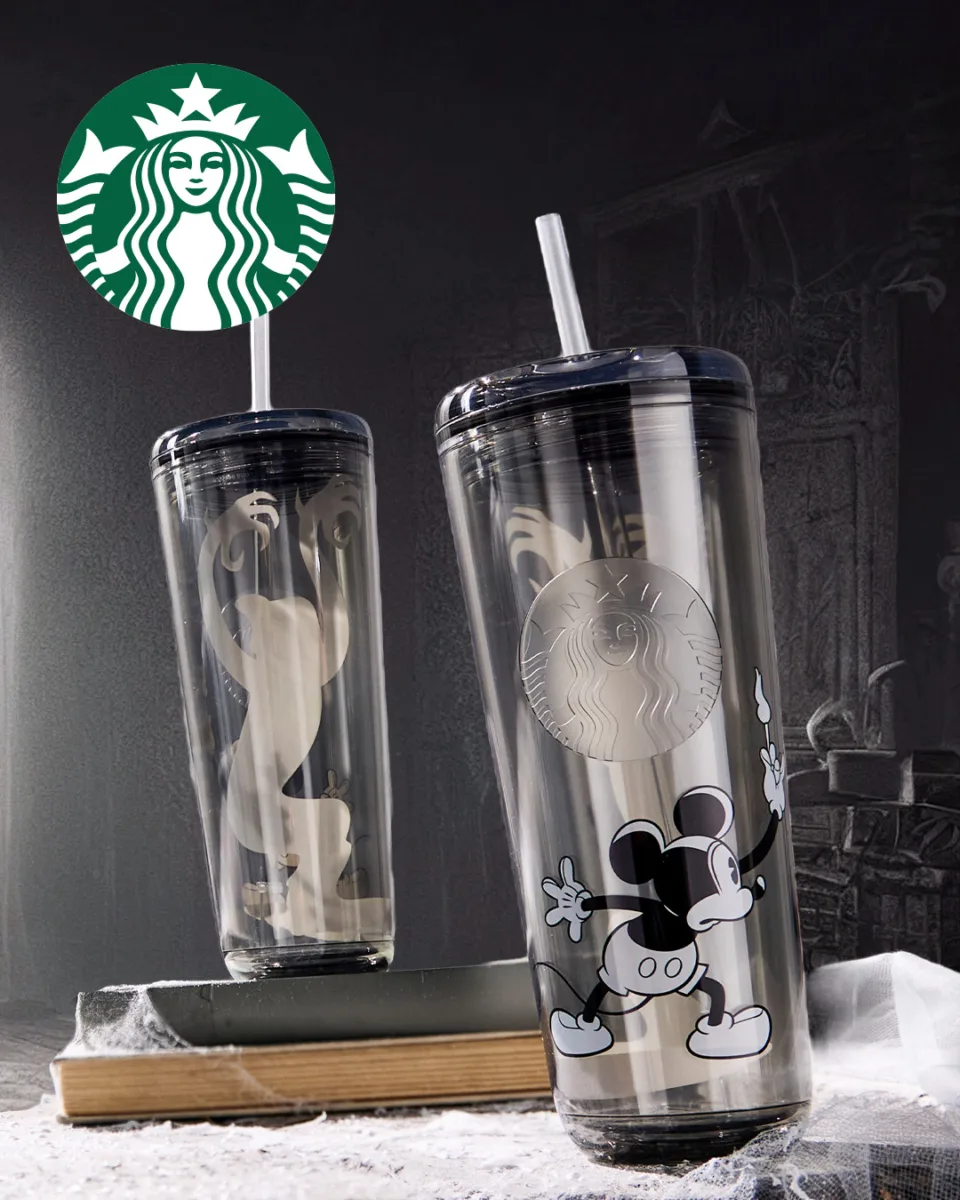Termo Starbucks de Disney Store con Mickey Mouse y la sombra fantasmal de The Haunted House sobre un libro antiguo con telarañas