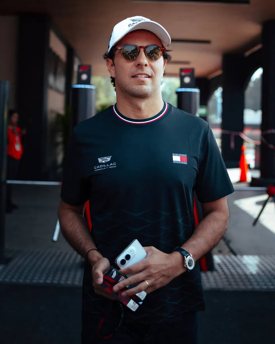 Checo Pérez llega al paddock del Autódromo Hermanos Rodríguez con playera negra de Cadillac Formula 1 Team y gorra blanca este jueves previo al GP de México 2026
